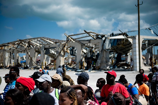 أشخاص يستقلون سفينة شحن لإجلاءها إلى ناسو في الميناء بعد إعصار دوريان
